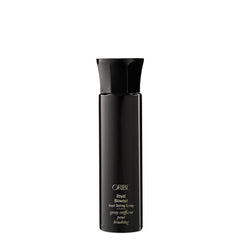Oribe Royal Blowout spray bottle releasing a light mist for smooth, protected hair.