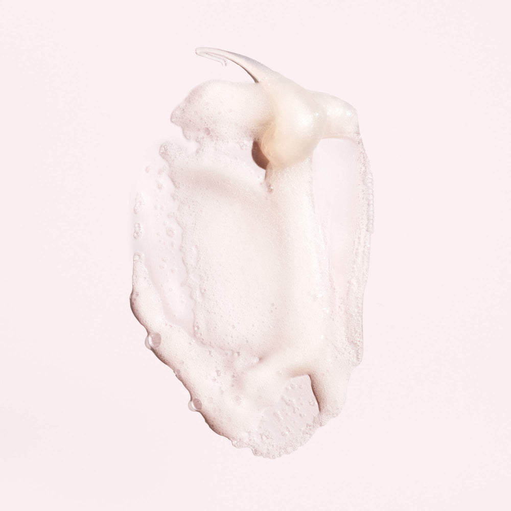 Oribe Serene Scalp Shampoo lather highlighting gentle cleansing for dry, itchy scalp.