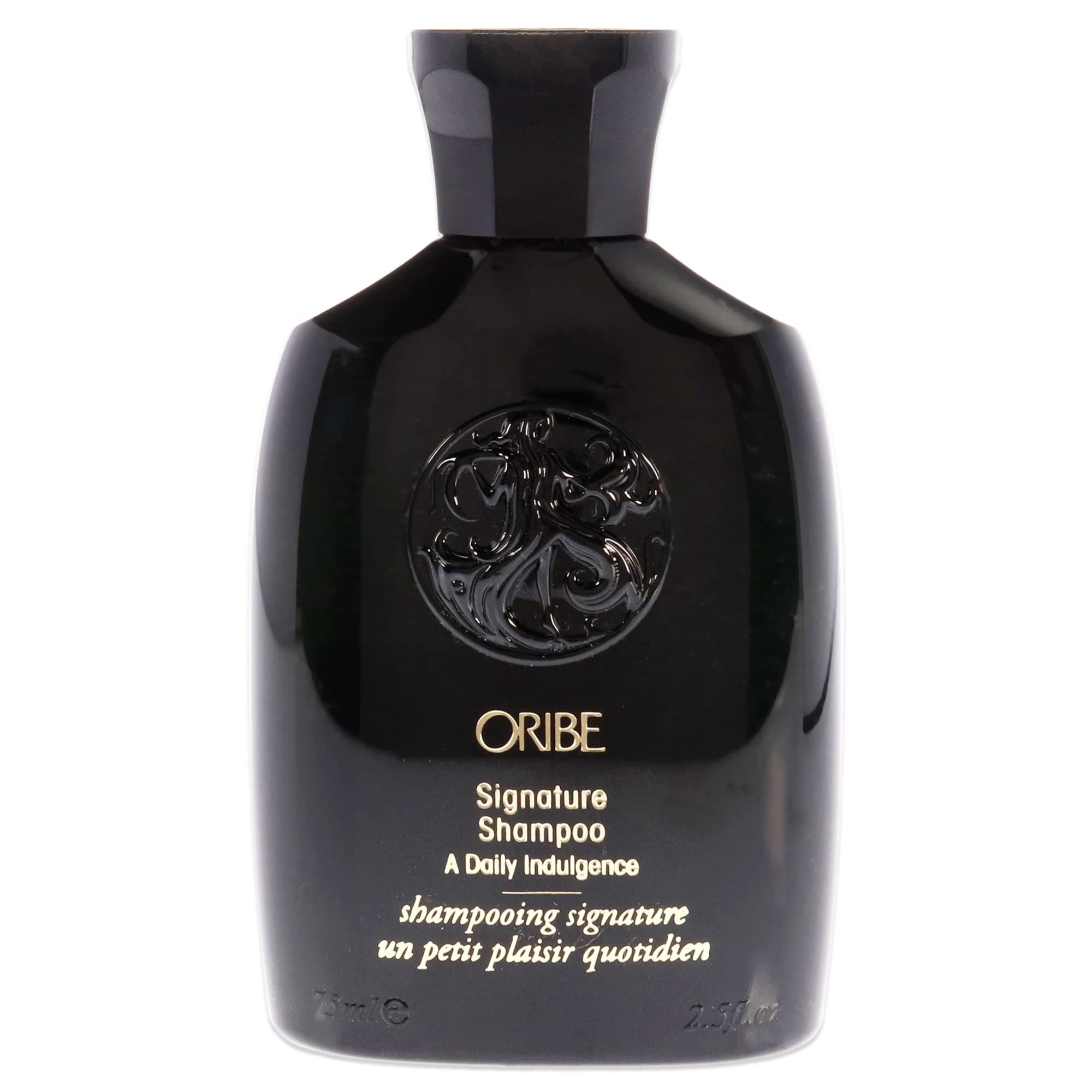 Oribe Signature Shampoo bottle pouring, providing a rich daily cleanse for all hair types.