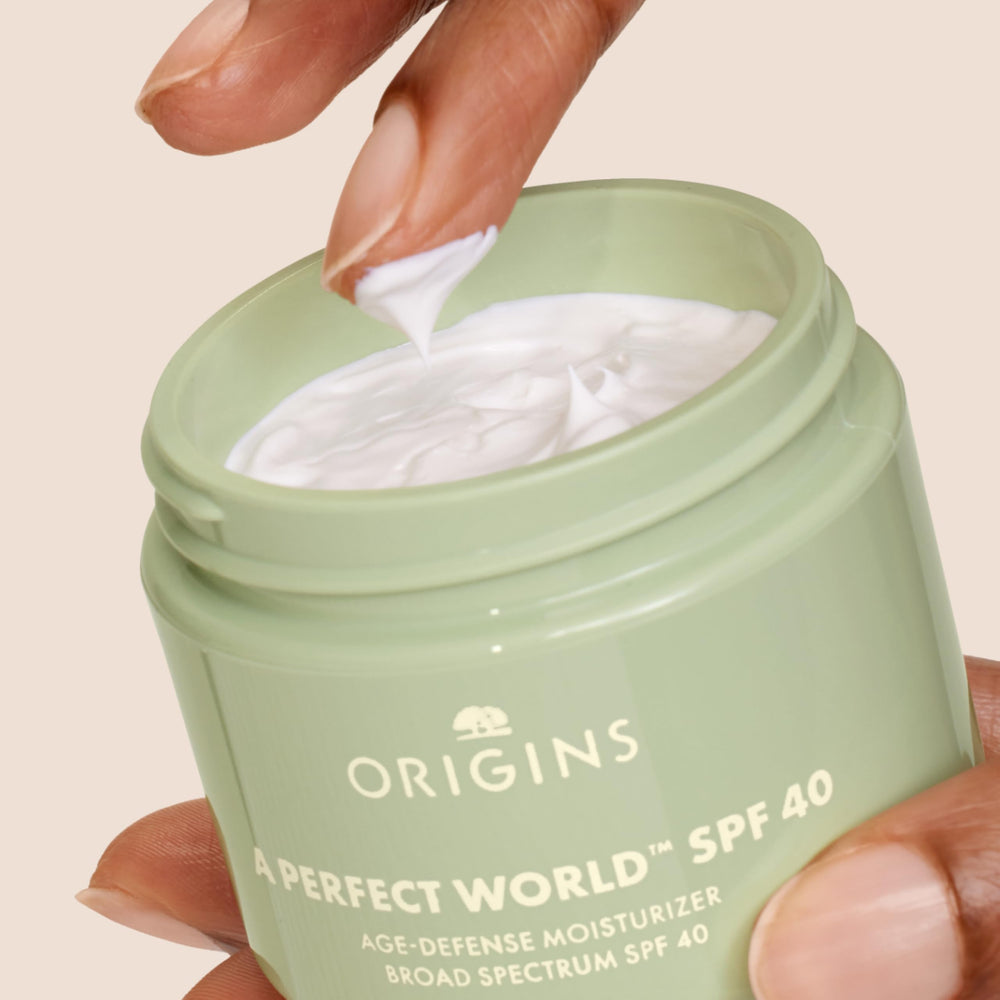 Origins A Perfect World moisturizer on hand demonstrates lightweight hydration for daily wear.
