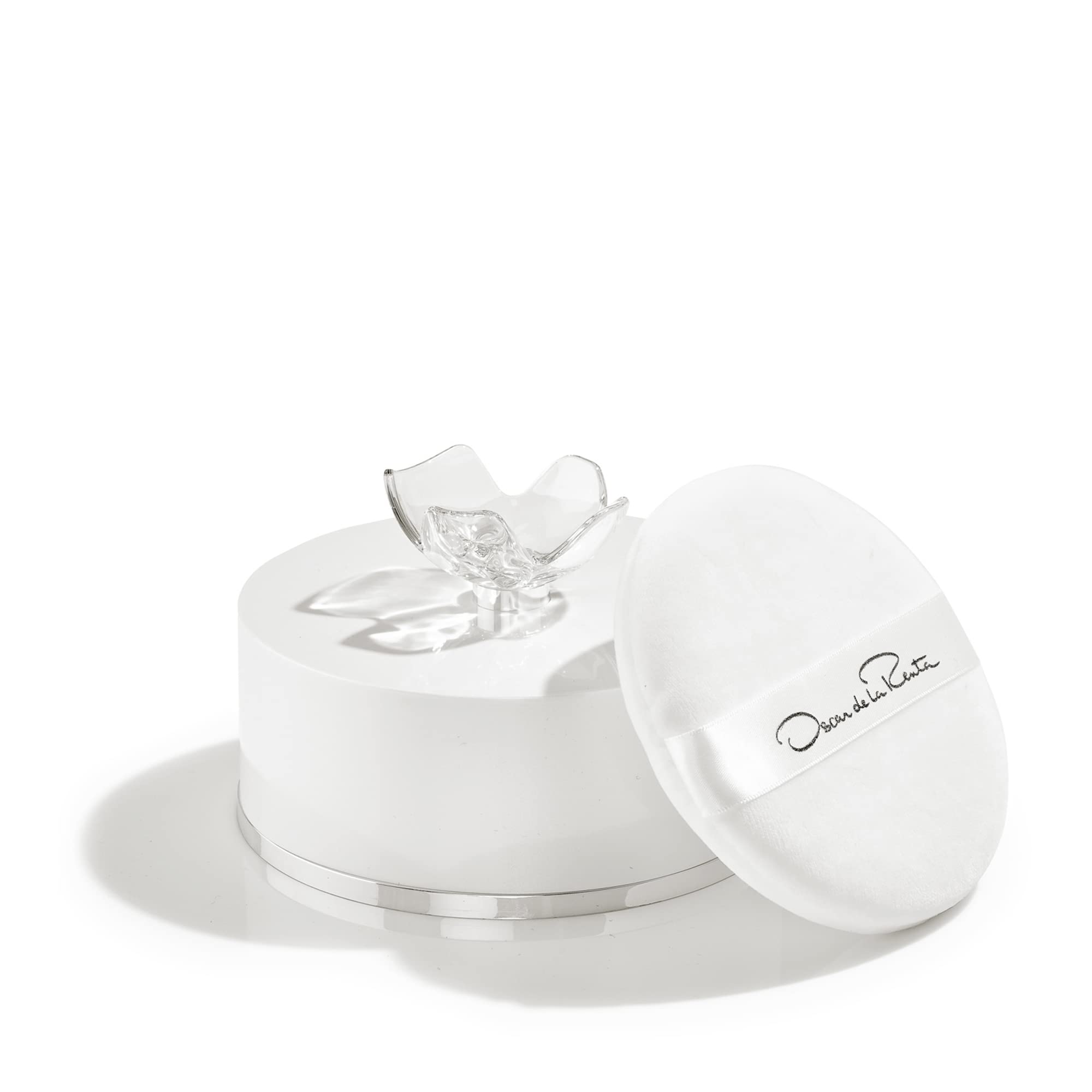 Close-up of Oscar Signature Dusting Powder on skin reveals fine texture for seamless wear.