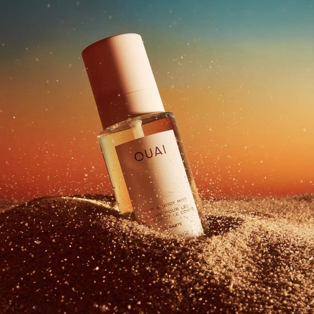 OUAI St. Barts bottle on beach scene evokes vacation vibes and quick refresh.
