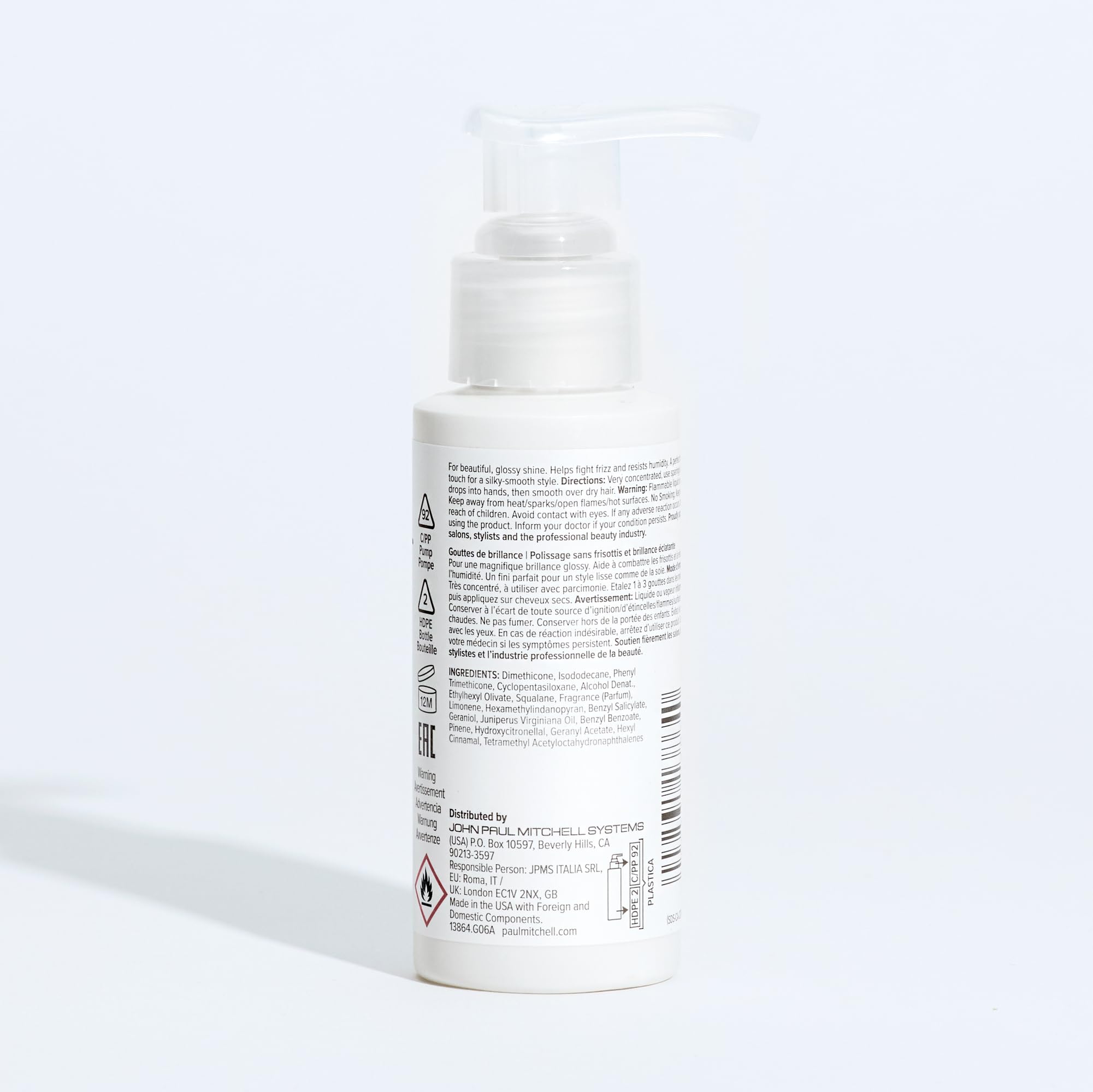 Paul Mitchell Gloss Drops on shelf beside styling tools for shine.