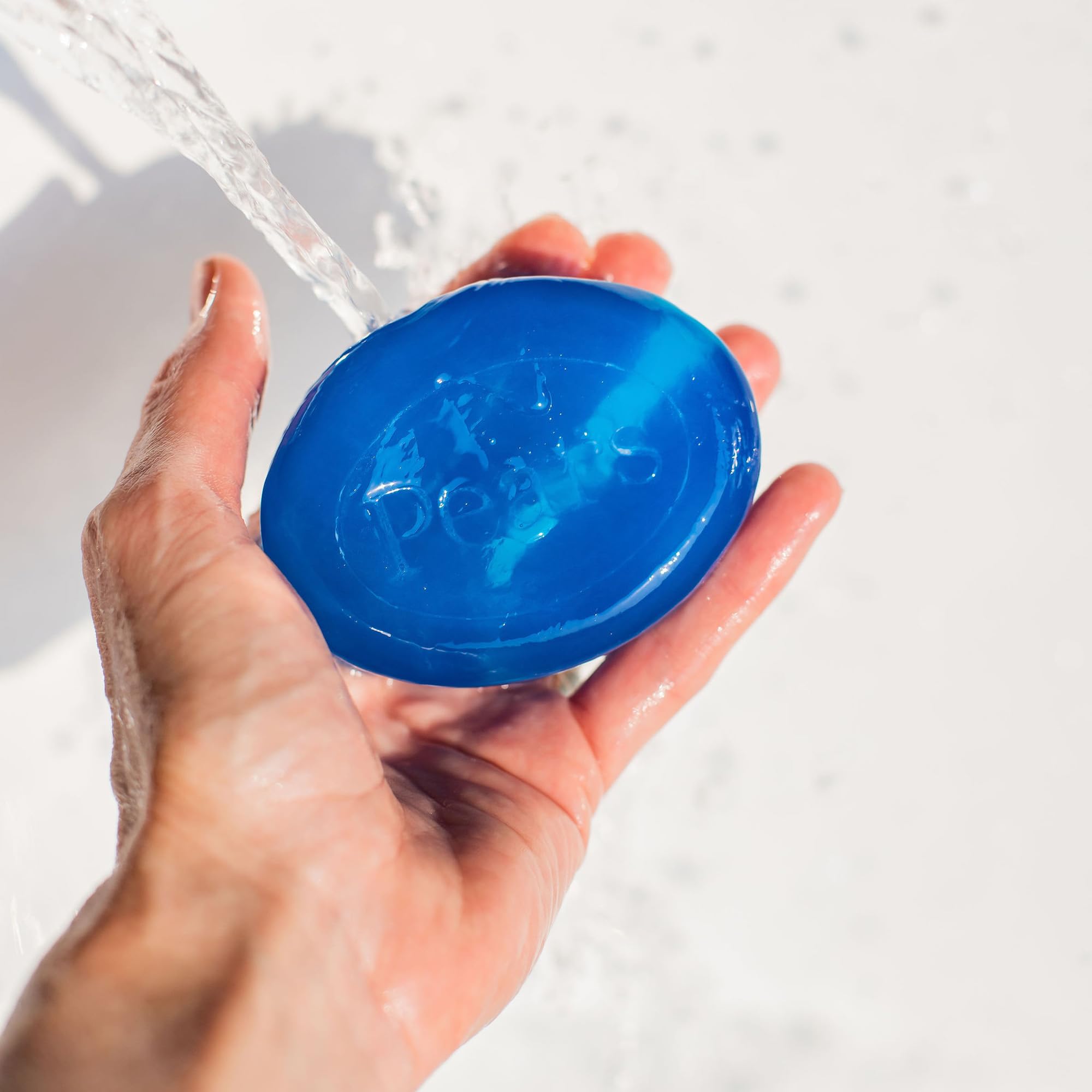 Pears translucent blue soap on skin suggests refreshing cleanse.