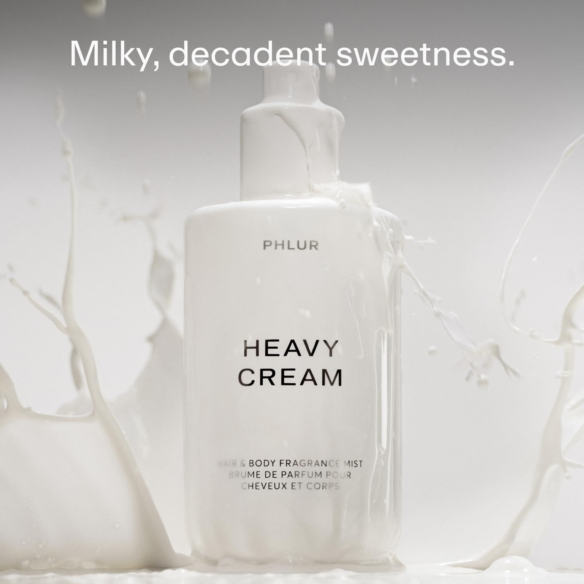 PHLUR Heavy Cream bottle being sprayed, illustrating hair and body use.