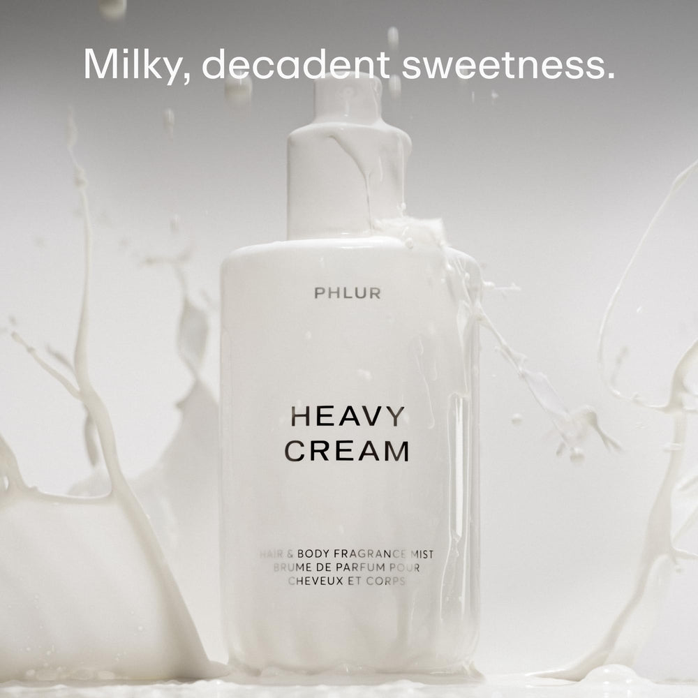 PHLUR Heavy Cream bottle being sprayed, illustrating hair and body use.