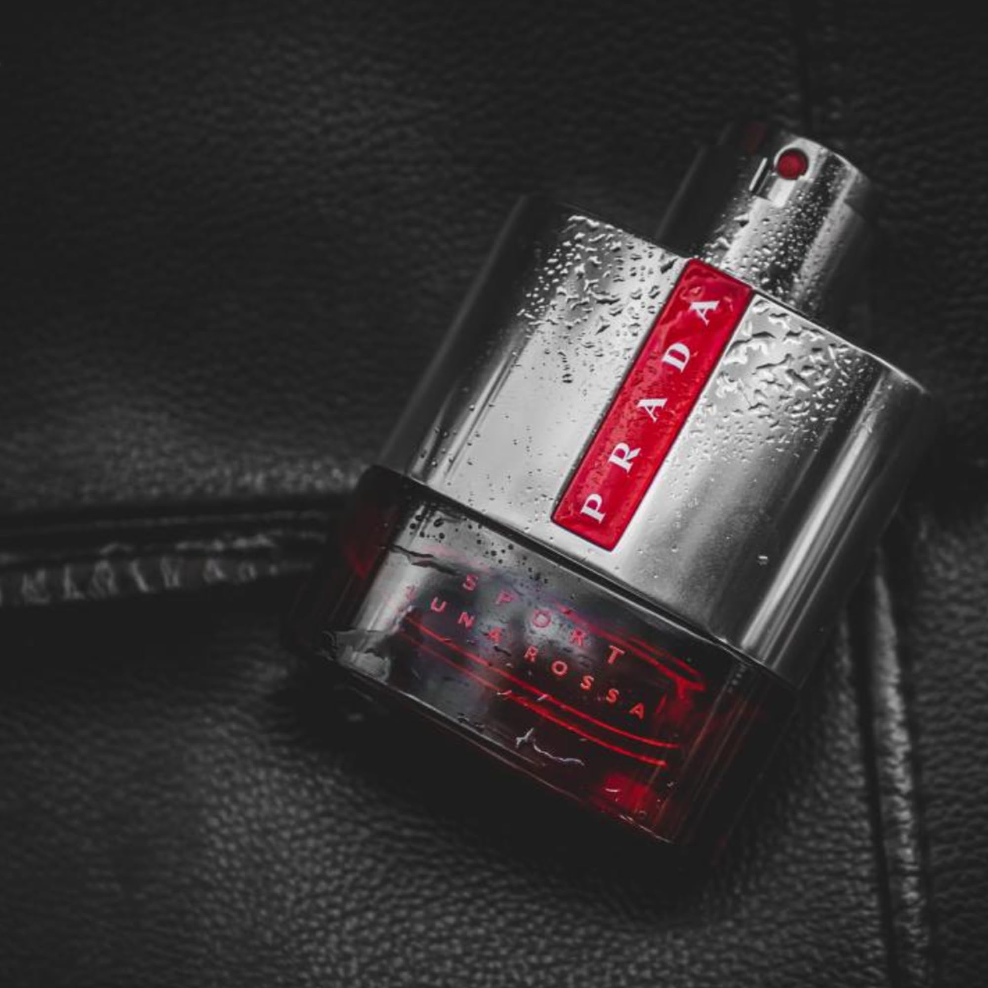 Prada Luna Rossa Sport bottle on surface, versatile fragrance companion.