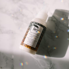 R+Co Sun Catcher Power C Leave-In bottle back with ingredients and usage notes