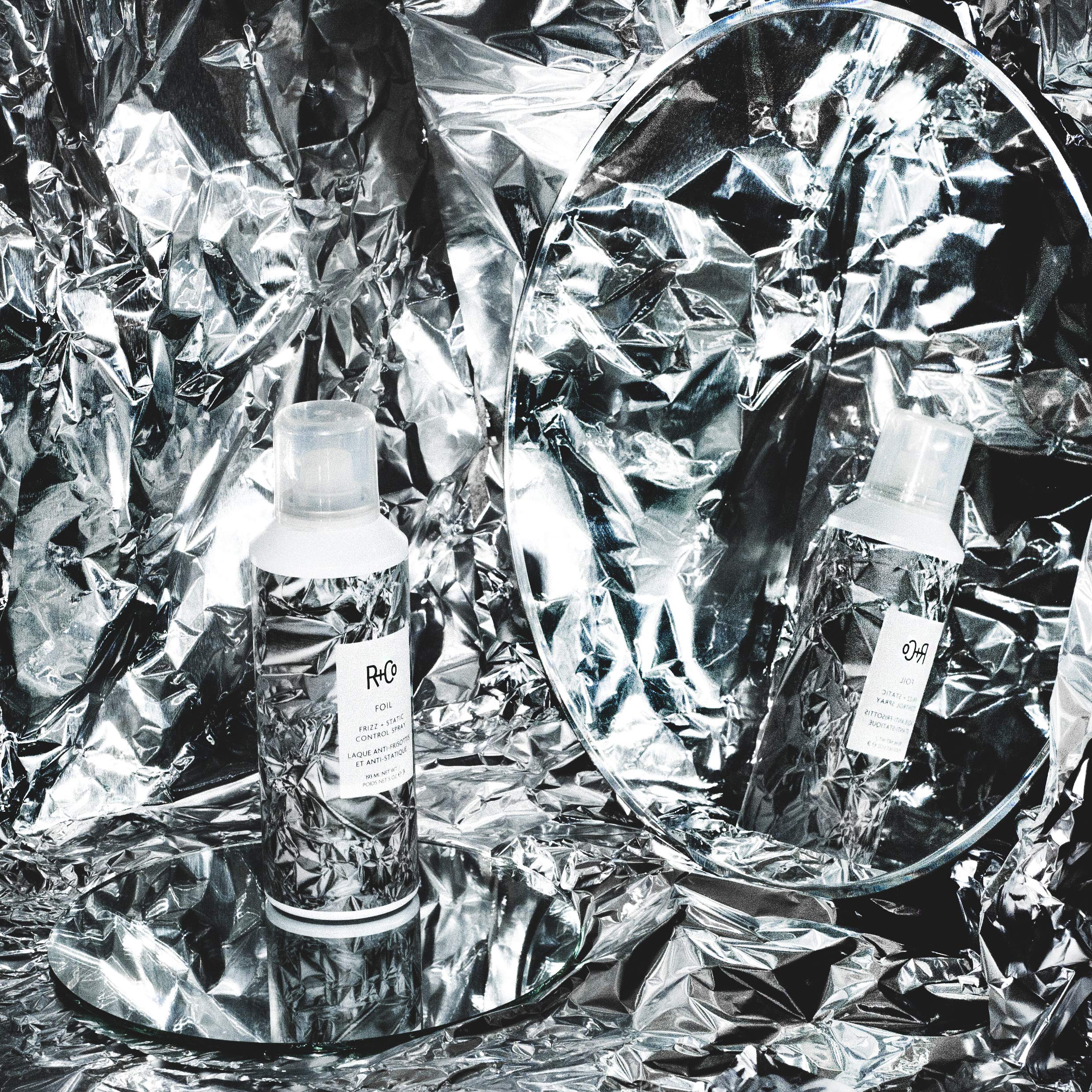 R+Co Foil Frizz + Static spray in use on hair during application.
