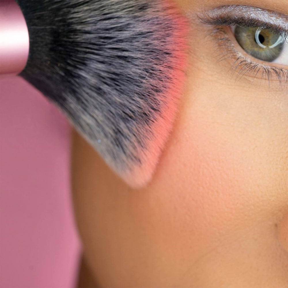 Real Techniques Mini Multitask Brush in hand for on-the-go touch-ups