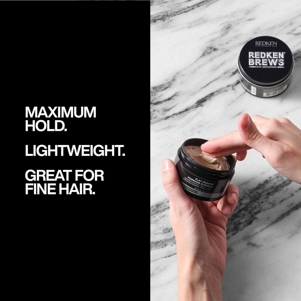 Hands applying Redken Brews Clay Pomade to sculpt volume and texture