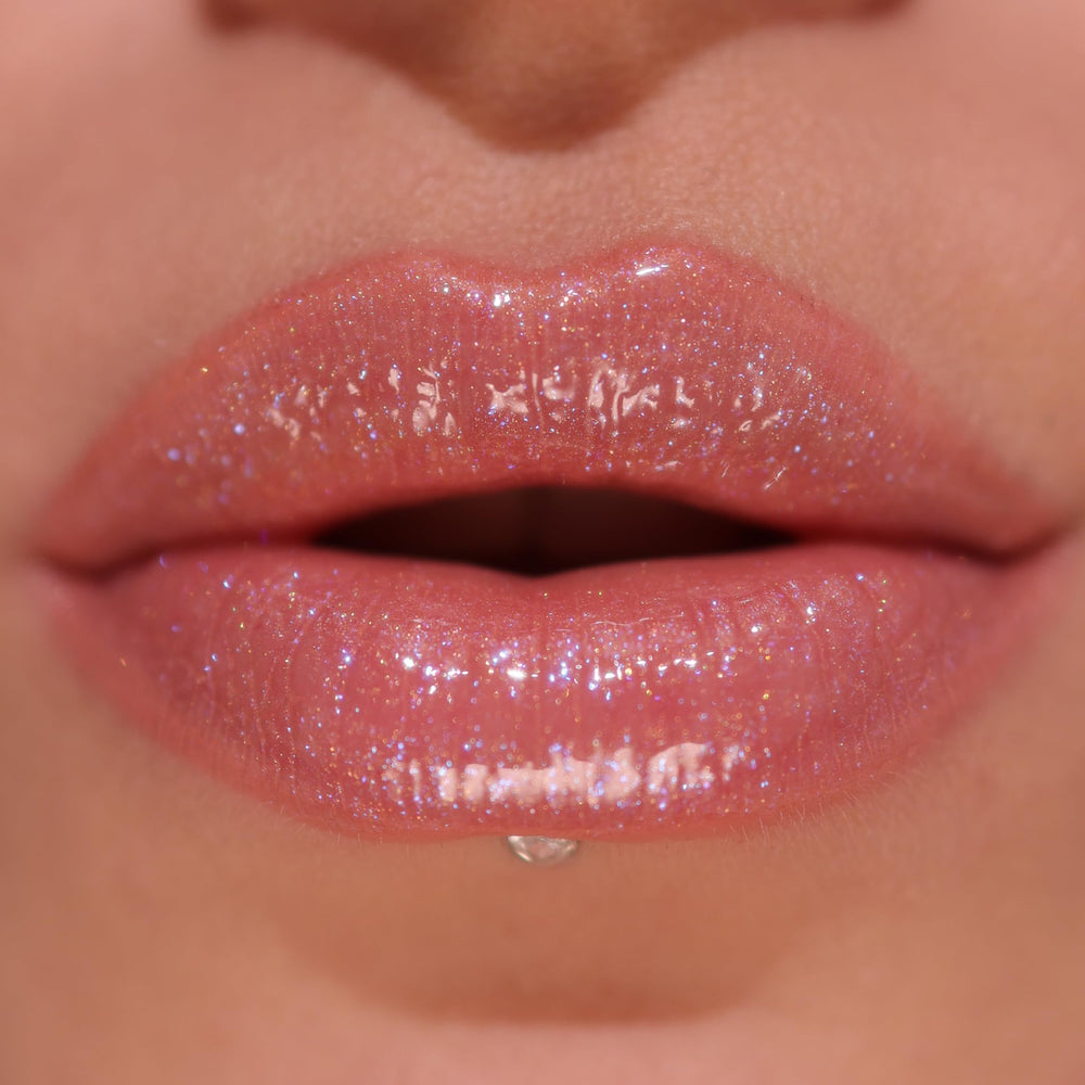 Revolution Pout Bomb Shimmer Shine Pink showcases vibrant semi-sheer color