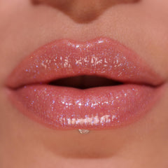 Revolution Pout Bomb Shimmer Shine Pink showcases vibrant semi-sheer color