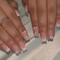 ROFIBUT pink French tip nails featuring embellishments for special occasions.