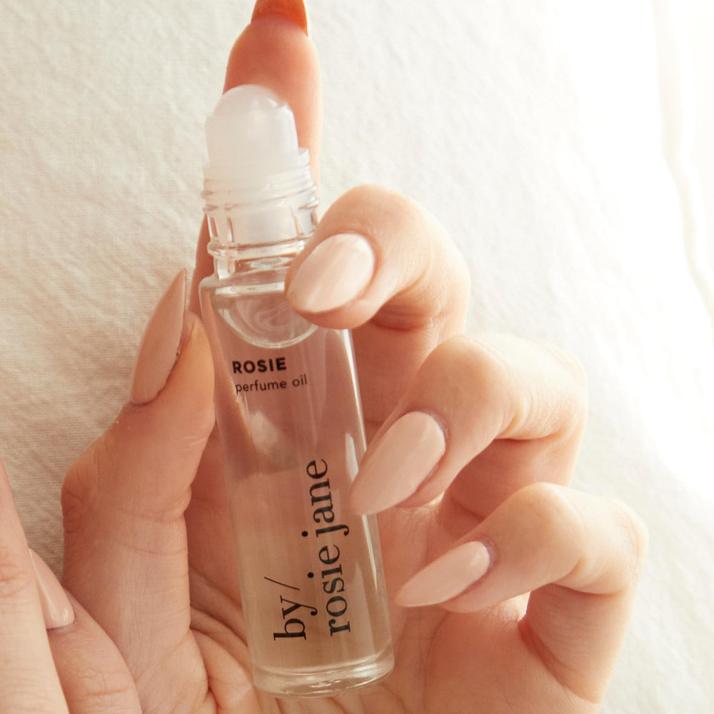 Rosie perfume oil roll-on demonstrates easy application on pulse points.