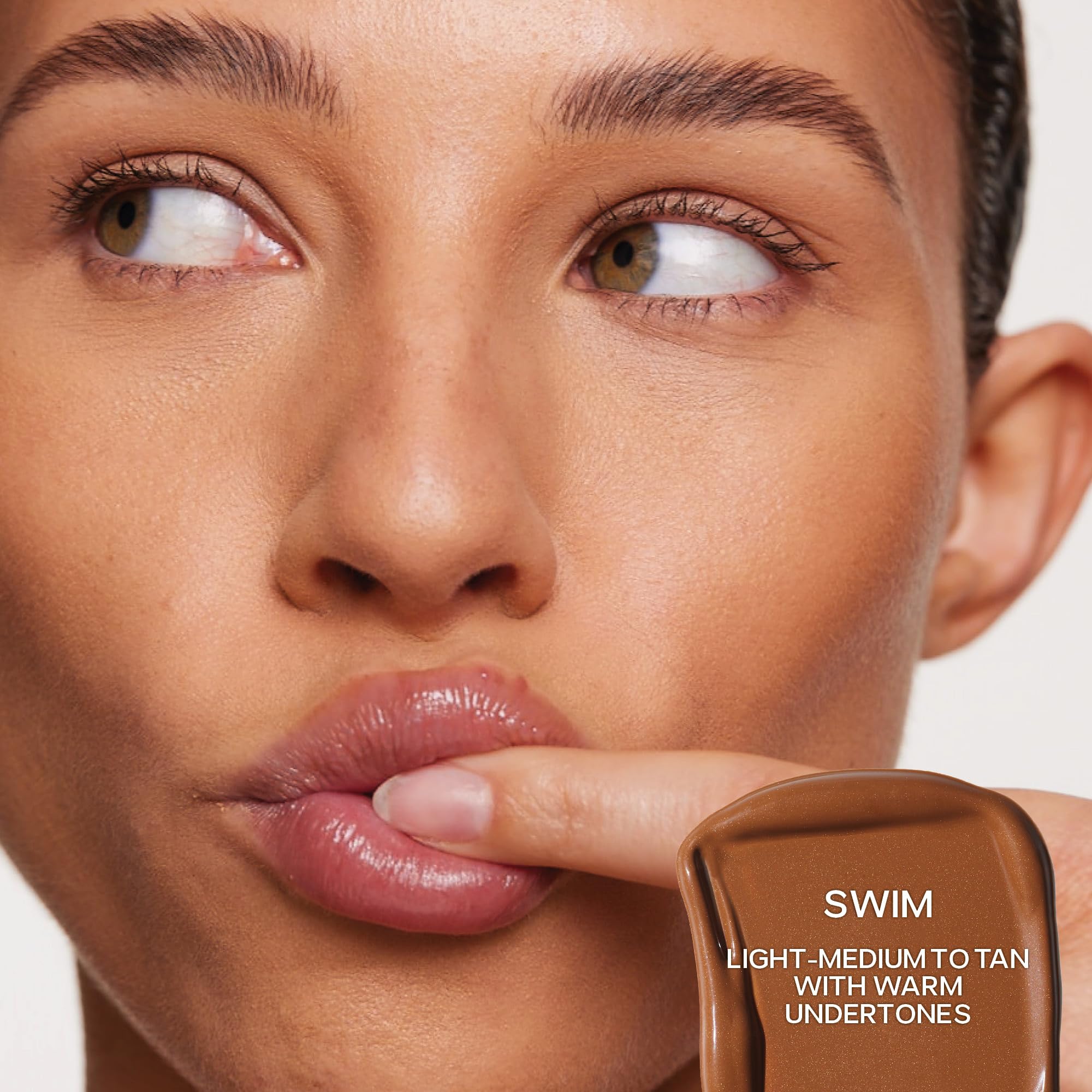 Saie Dew Bronze swirled on cheek for natural bronze definition.