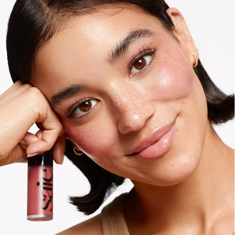 Saie Dew Liquid Blush shimmer-glow on face highlights lit-from-within radiance.