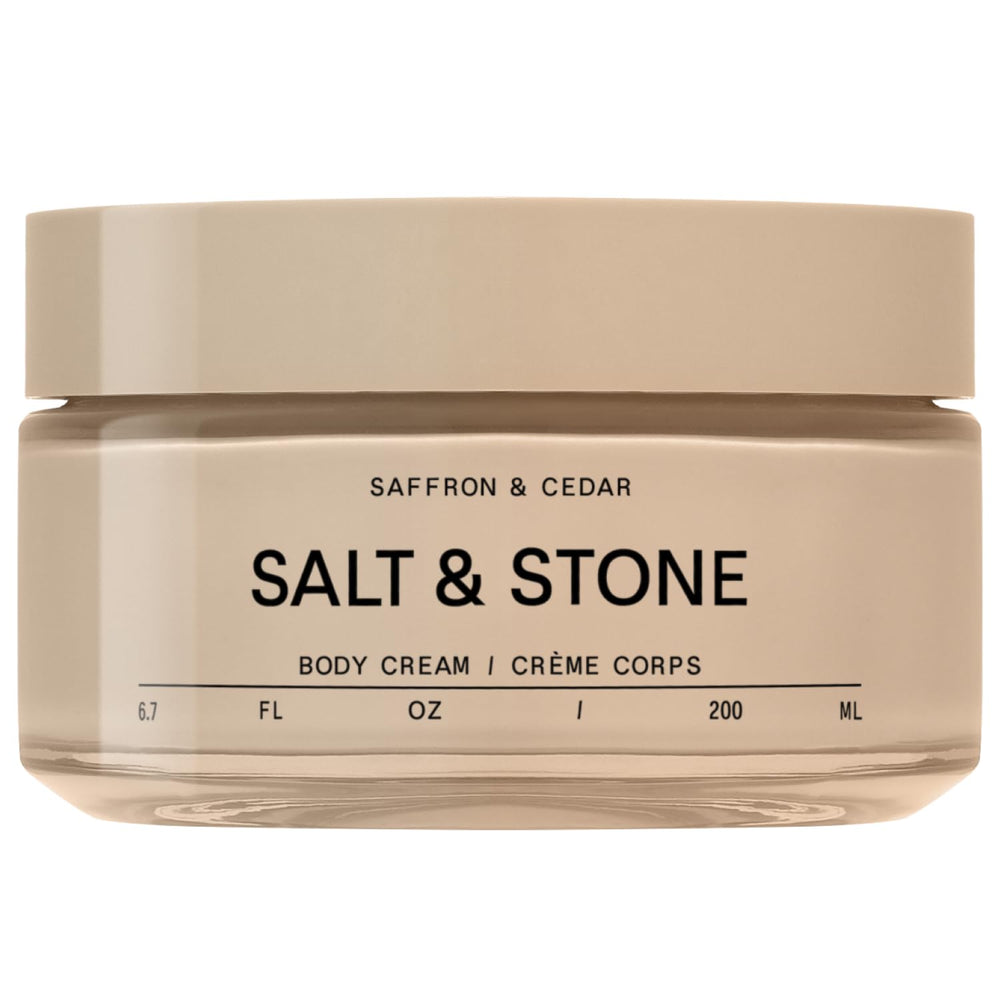 Salt & Stone Body Cream bottle front with warm saffron cedar scent promise.