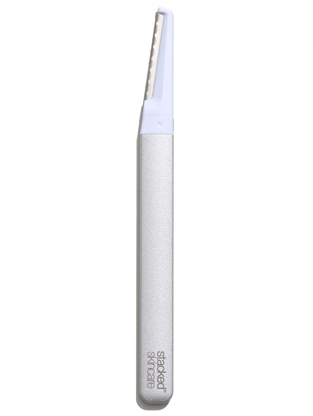 StackedSkincare dermaplaning tool with replaceable blades for gentle peach fuzz removal.