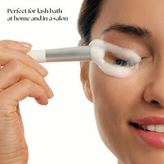 STACY LASH eyelash cleansing brush shown in packaging, highlighting a compact design for travel.
