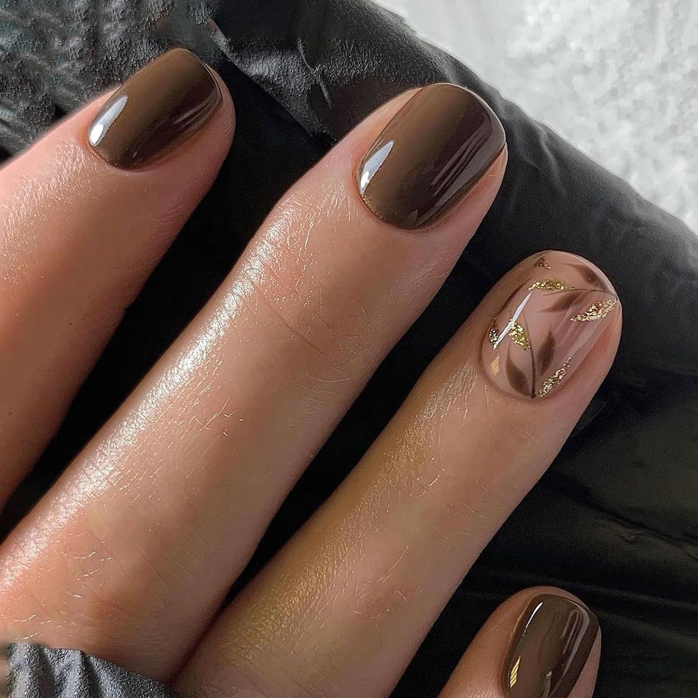 Uñas postizas Stbisen en marrón oscuro con hojas doradas y brillo.