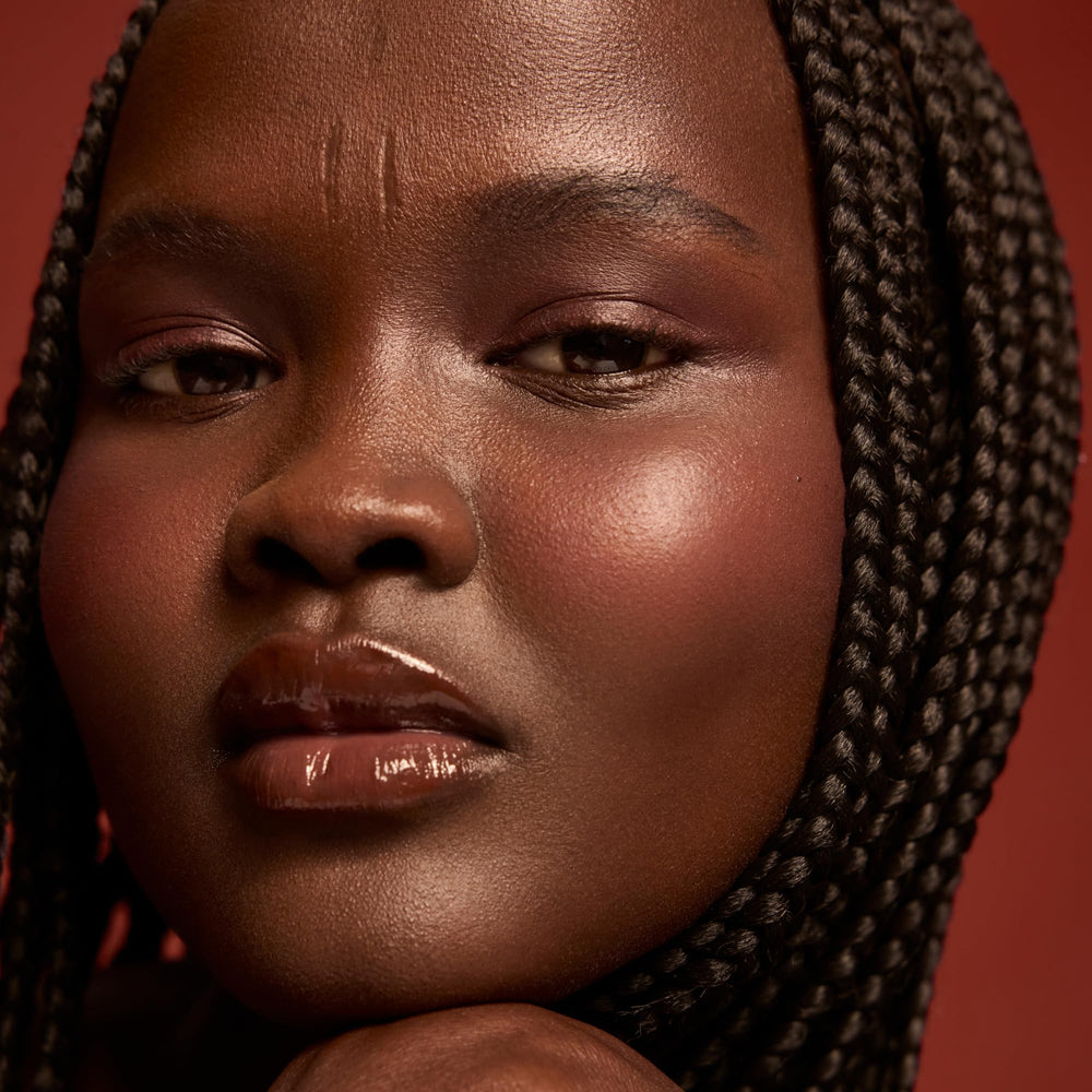 Dream Lip Oil Midnight Berry on lips adds gloss and dimension.