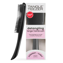 Tangle Teezer Large Ultimate Detangler with wide paddle gliding through wet or dry hair for smoother results.