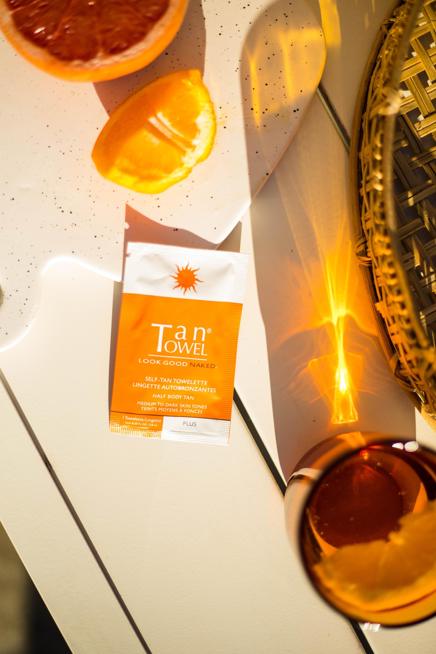 TanTowel half-body towelettes being unfolded for easy, streak-free application.