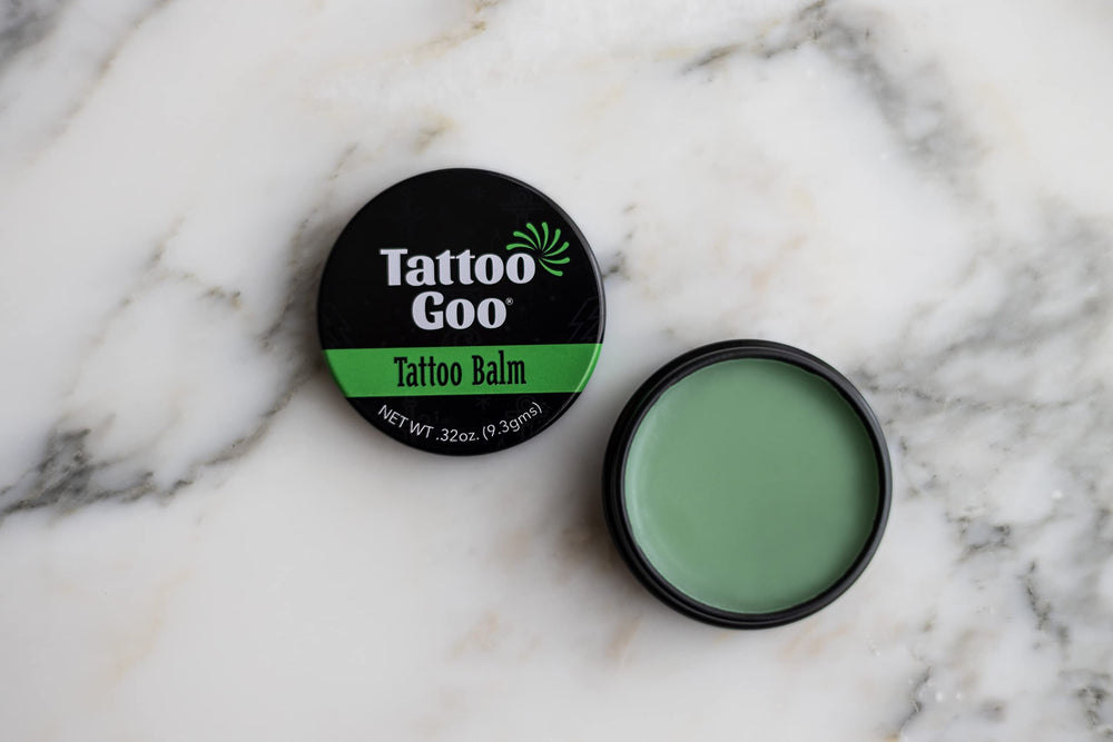 Applying Tattoo Goo balm to healing tattoo in action