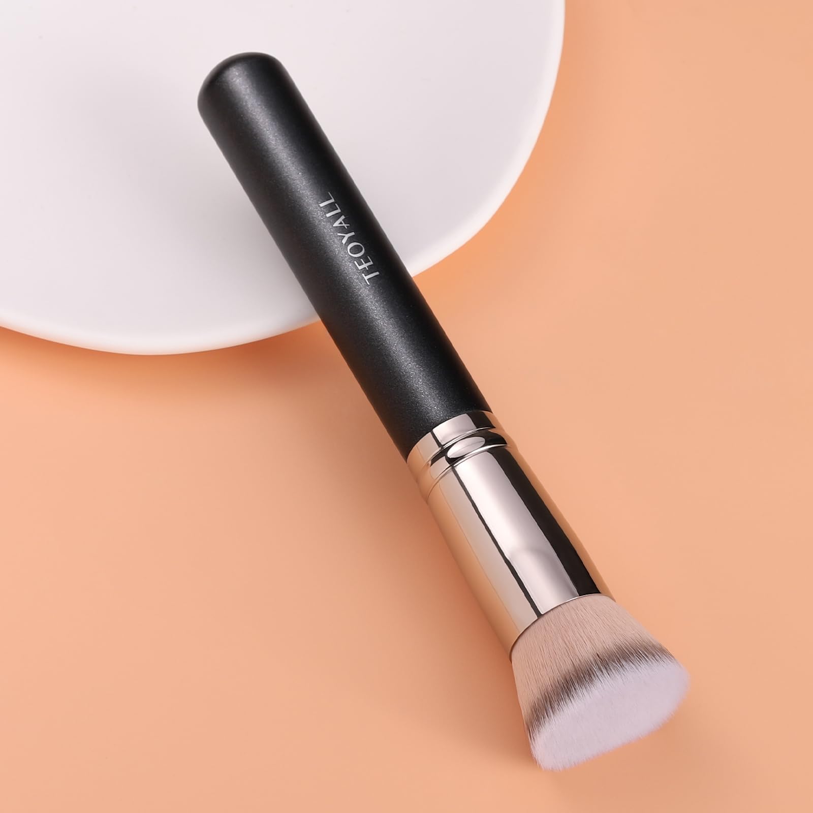 TEOYALL Kabuki brush close-up applying foundation for seamless buffing.