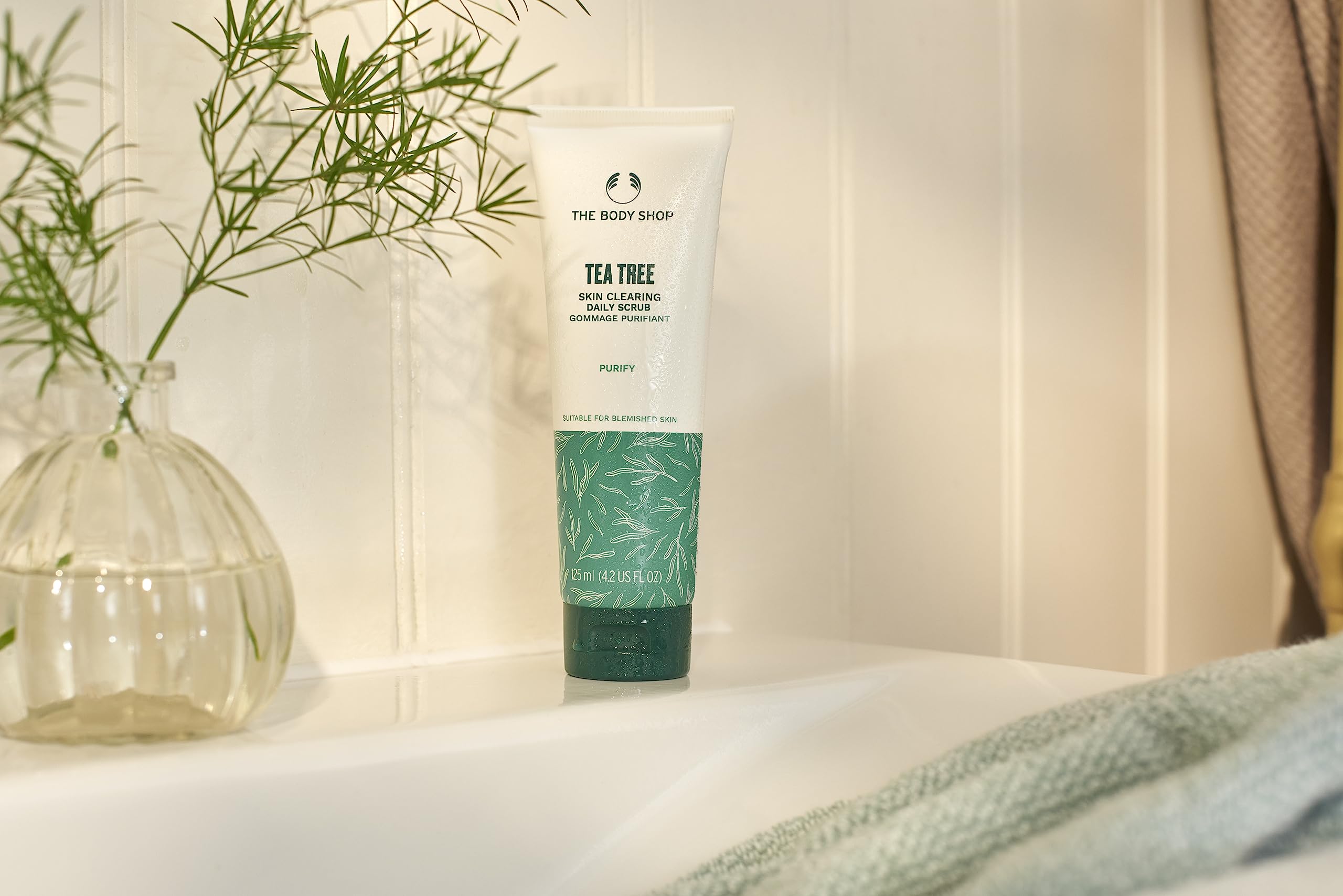 The Body Shop exfoliante de árbol de té: aplicación en mano para rutina diaria.