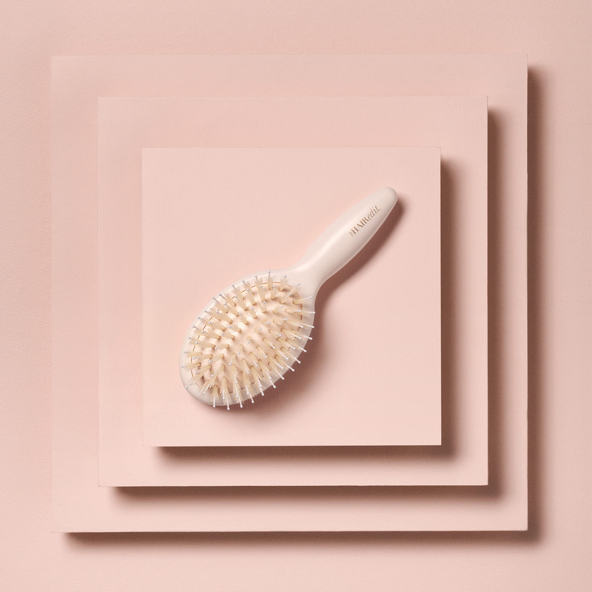 The Hair Edit compact portable brush fits in a bag for quick touch-ups