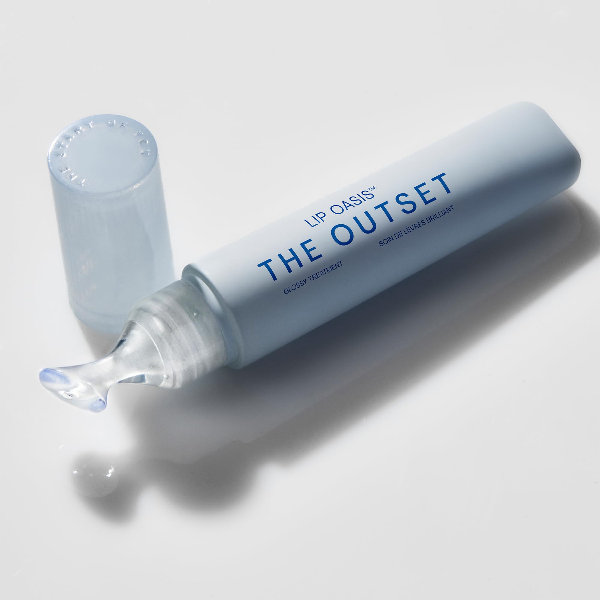 The Outset Lip Oasis glossy application swatch shows a smooth, non-sticky shine.