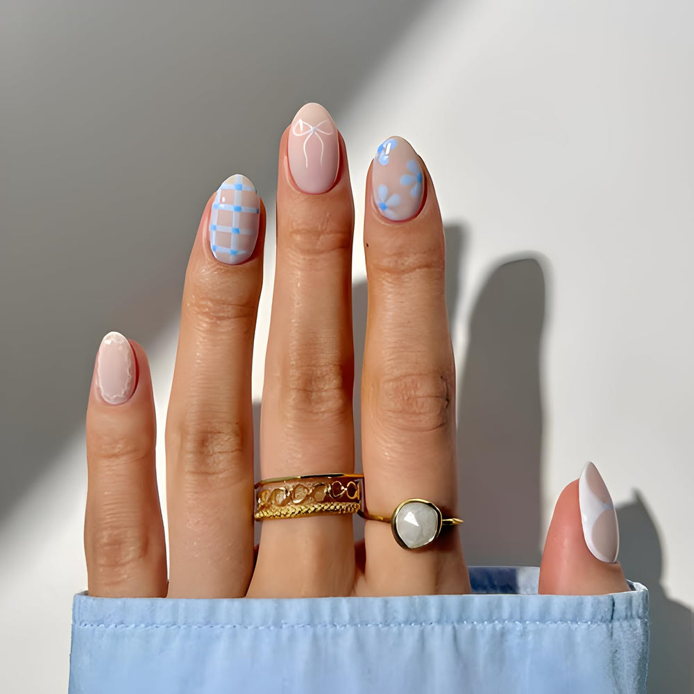 Uñas falsas Tnbuokas en forma almendra con lazo blanco y acabado brillante.