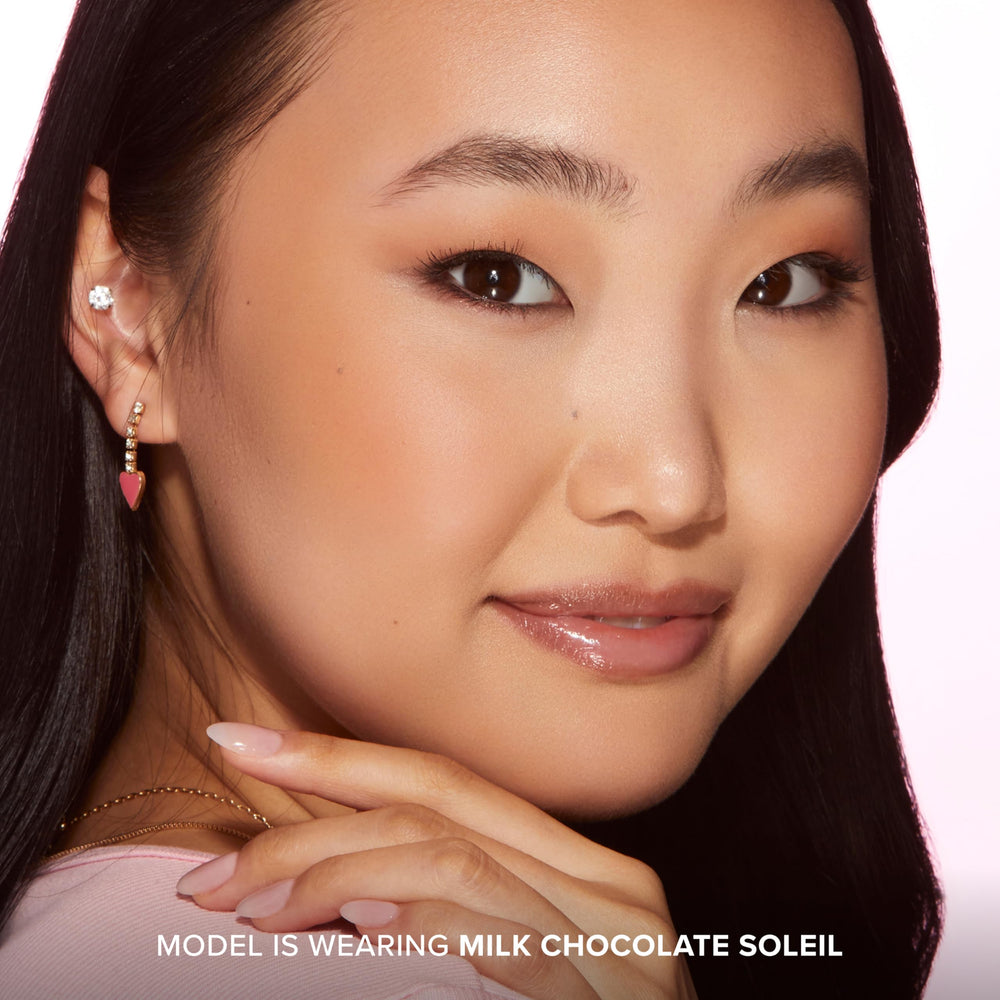Applying bronzer to cheekbone for sun-kissed contour in natural light