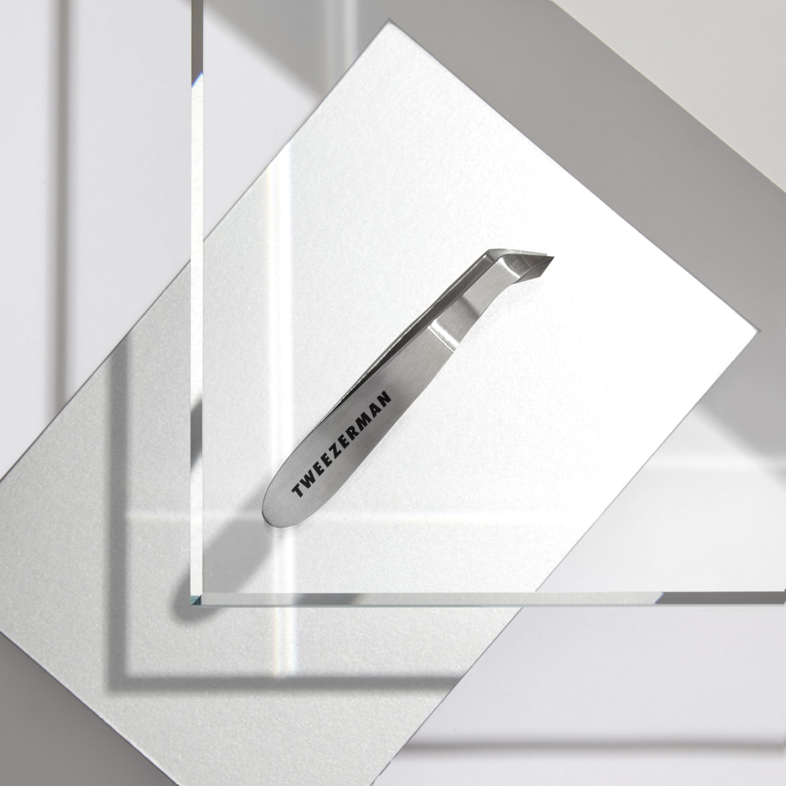 Tweezerman Mini Squeeze Cuticle Nipper beside travel case for on-the-go grooming.