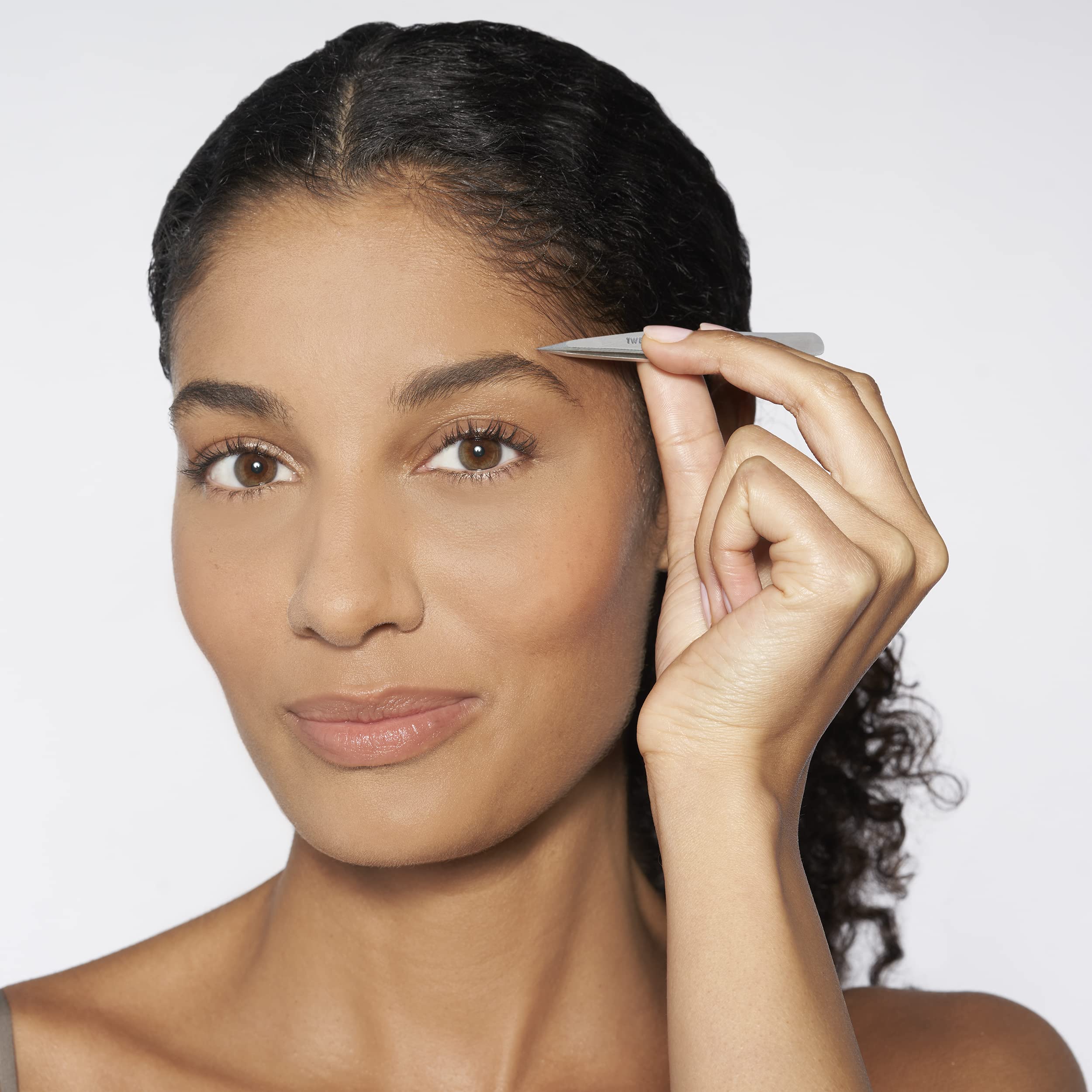 Tweezerman Petite Slant Tweezer used to shape brows with controlled precision.