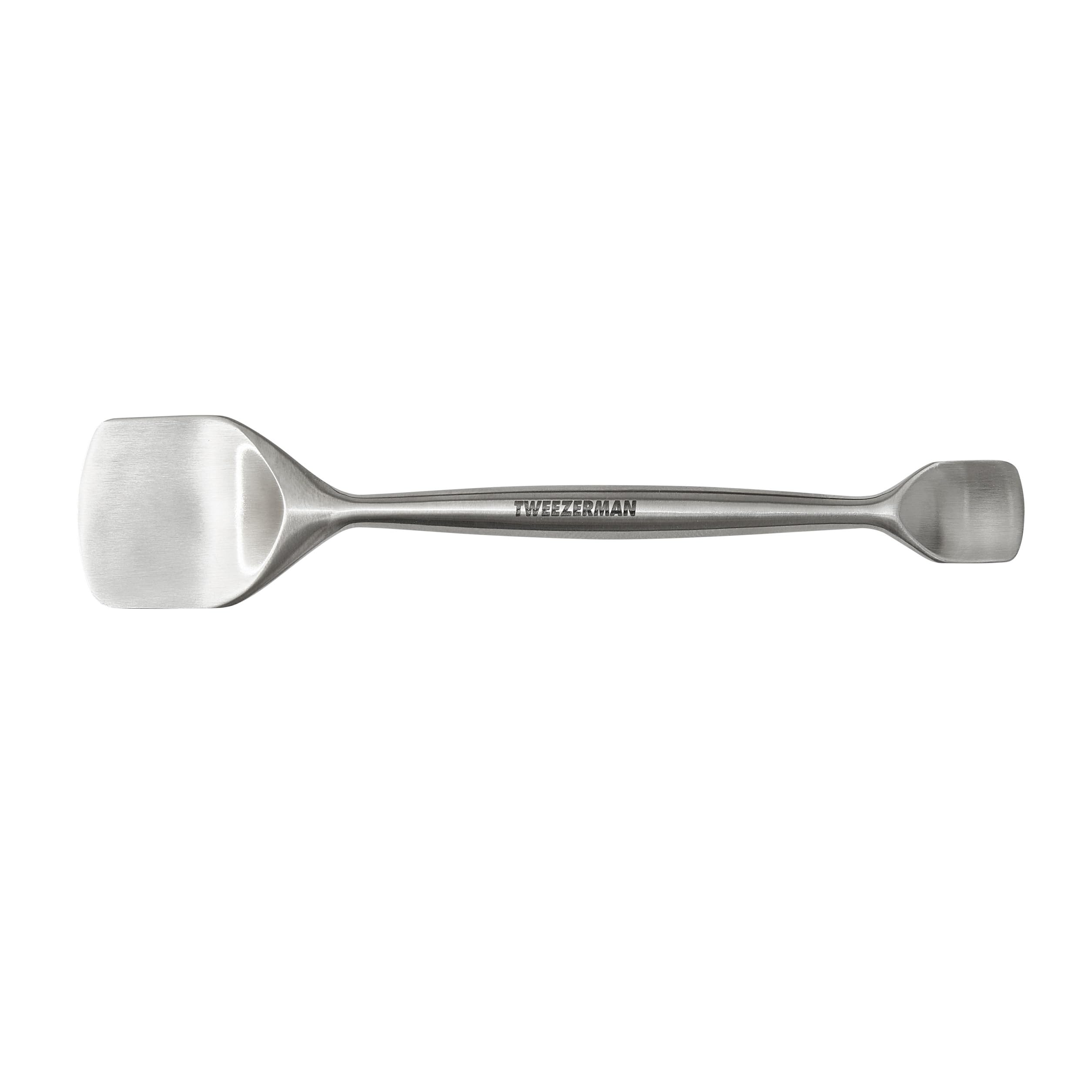 Tweezerman Pore Prep Tool on the forehead with the large end for broad cleansing.