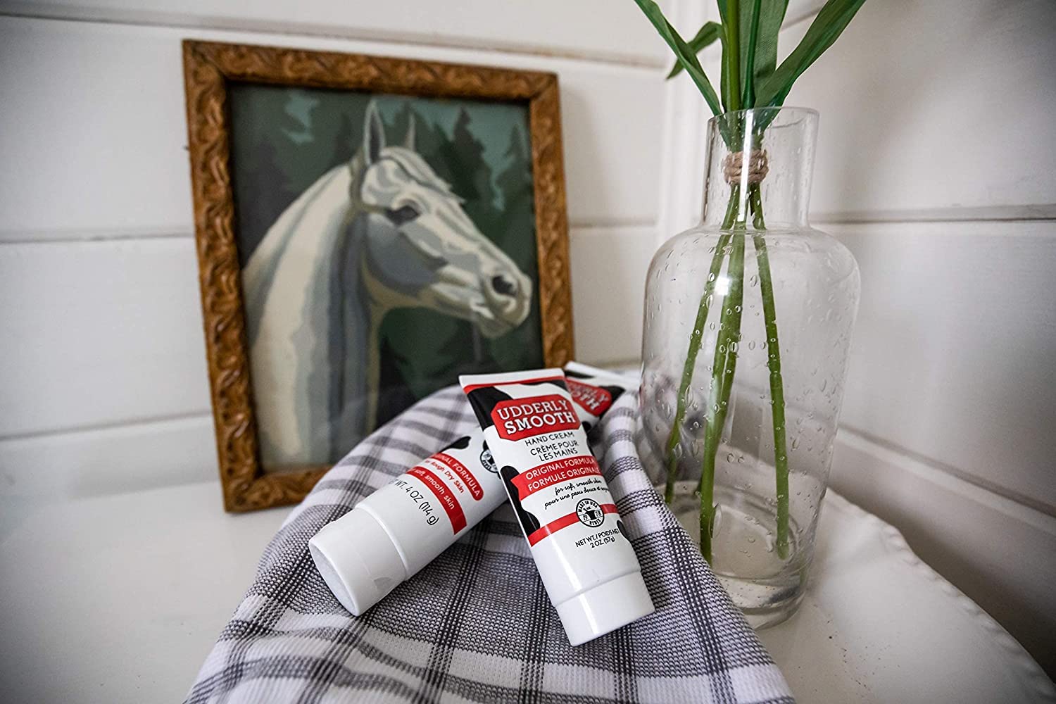Udderly Smooth hand cream beside a travel bag for on-the-go care