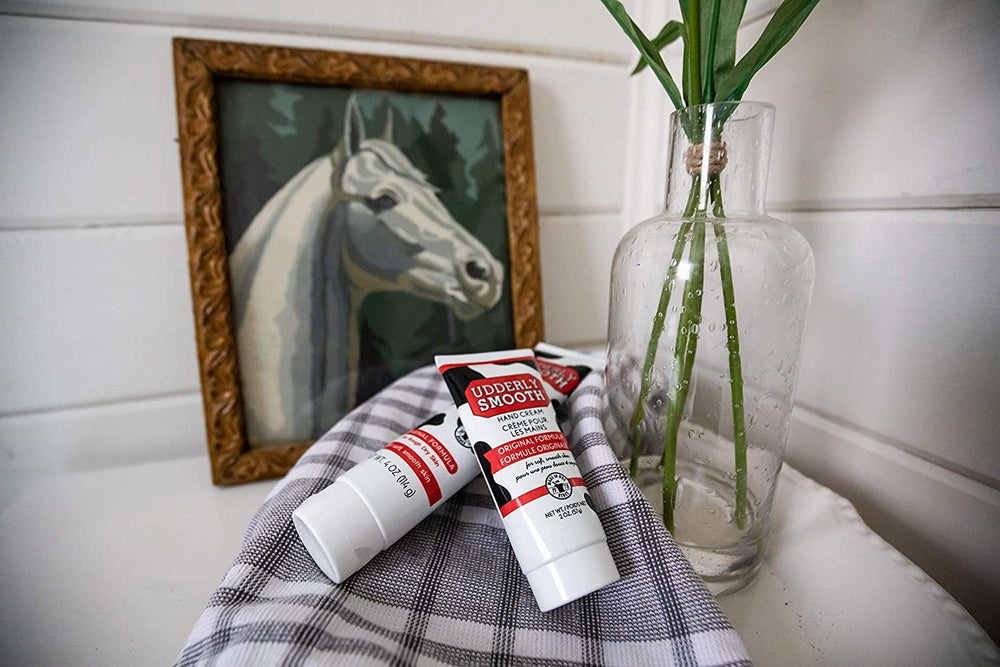 Udderly Smooth hand cream beside a travel bag for on-the-go care