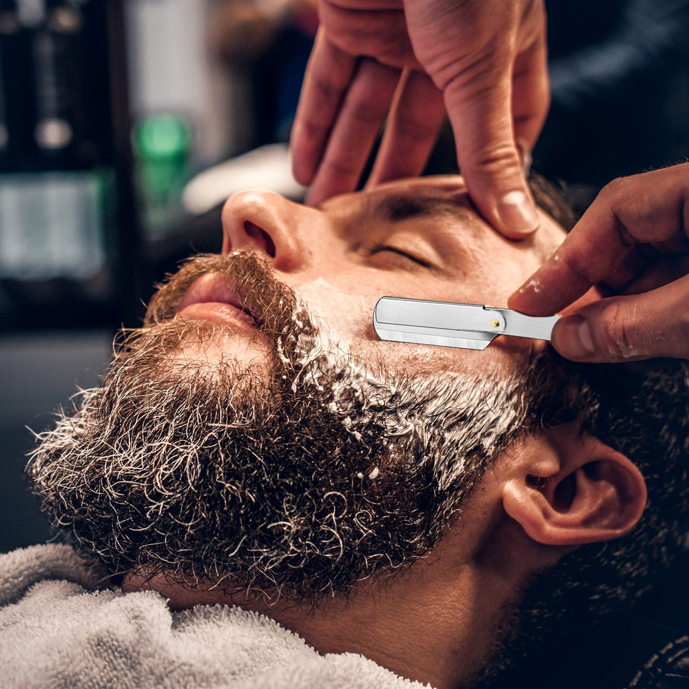Elegant silver razor with brass accents for refined grooming.