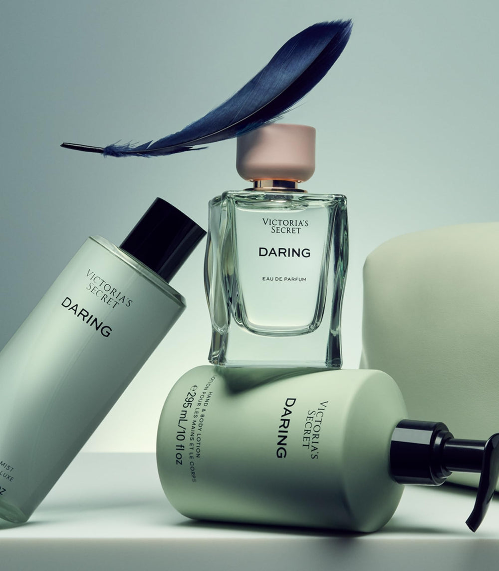 Elegant packaging shot for Victoria's Secret Daring, suggesting lotion layering for longer fragrance