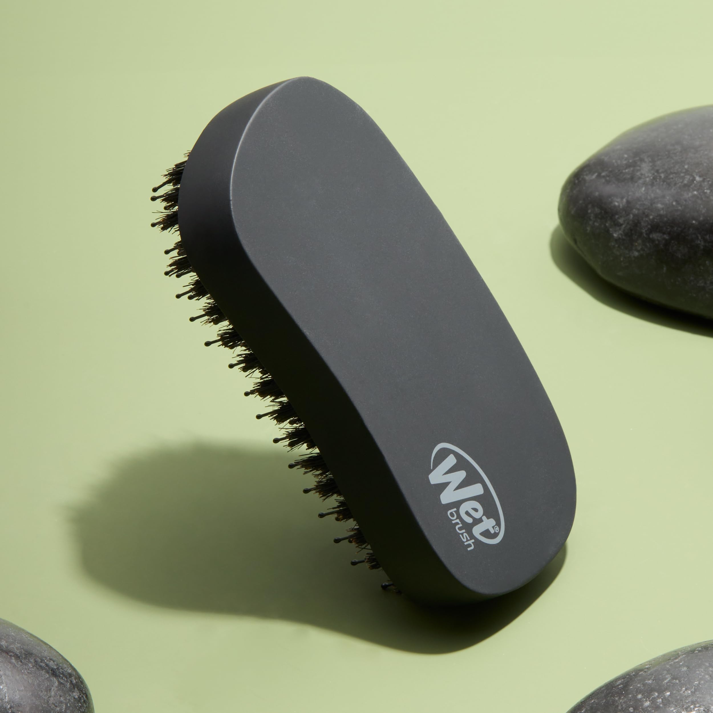Wet Brush Shine Enhancer in hand demonstrates palm-sized ergonomic grip for easy styling